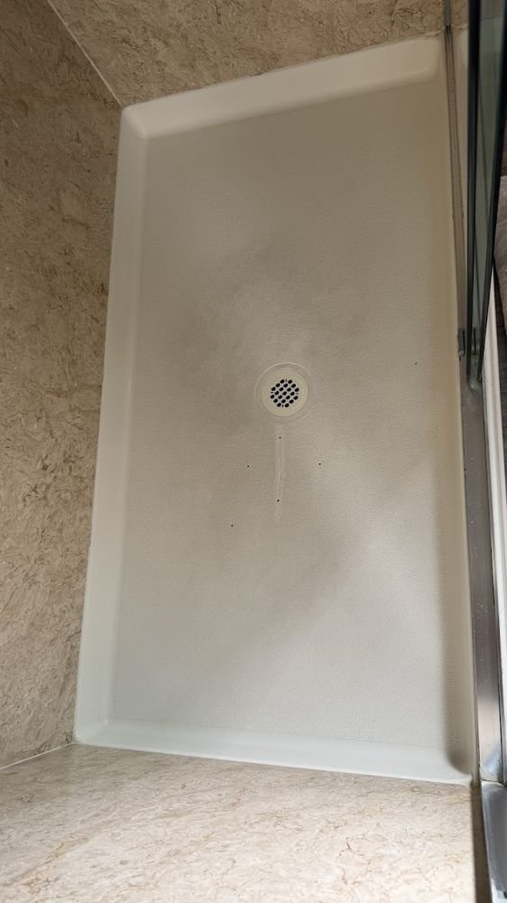 Shower pan with visible crack before repair