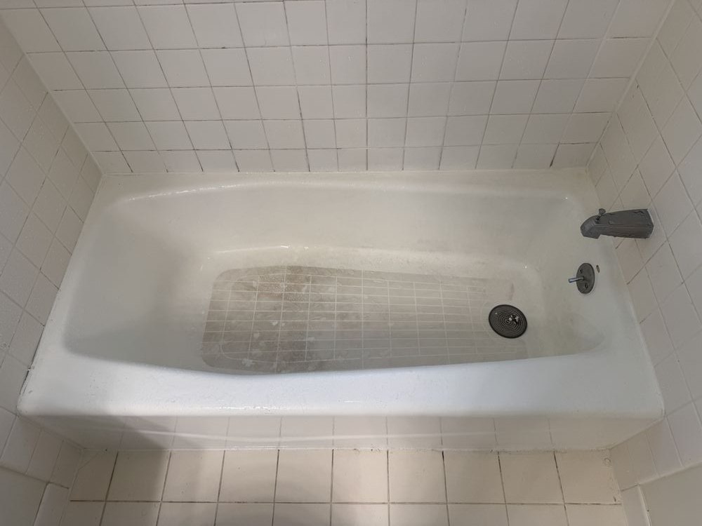 Bathtub with rust stain and worn finish before refinishing