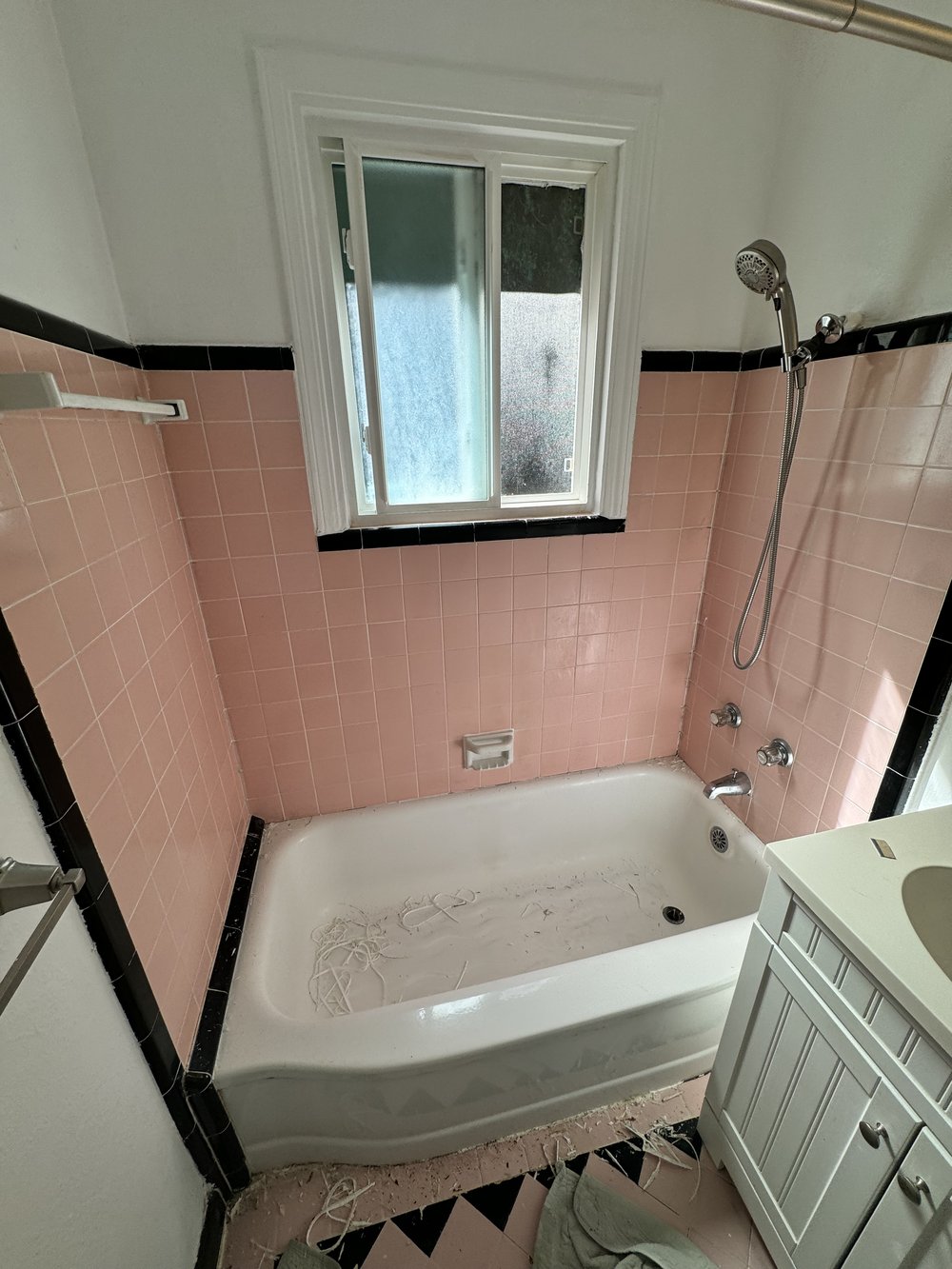Before refinishing in Campbell, CA &mdash; alcove tub in salmon-pink tile bath with black border trim and diamond-pattern floor