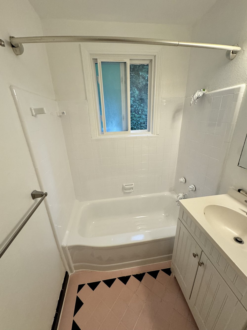 After refinishing in Campbell, CA &mdash; white wall tile, reglazed alcove tub, and updated shower surround with original floor kept