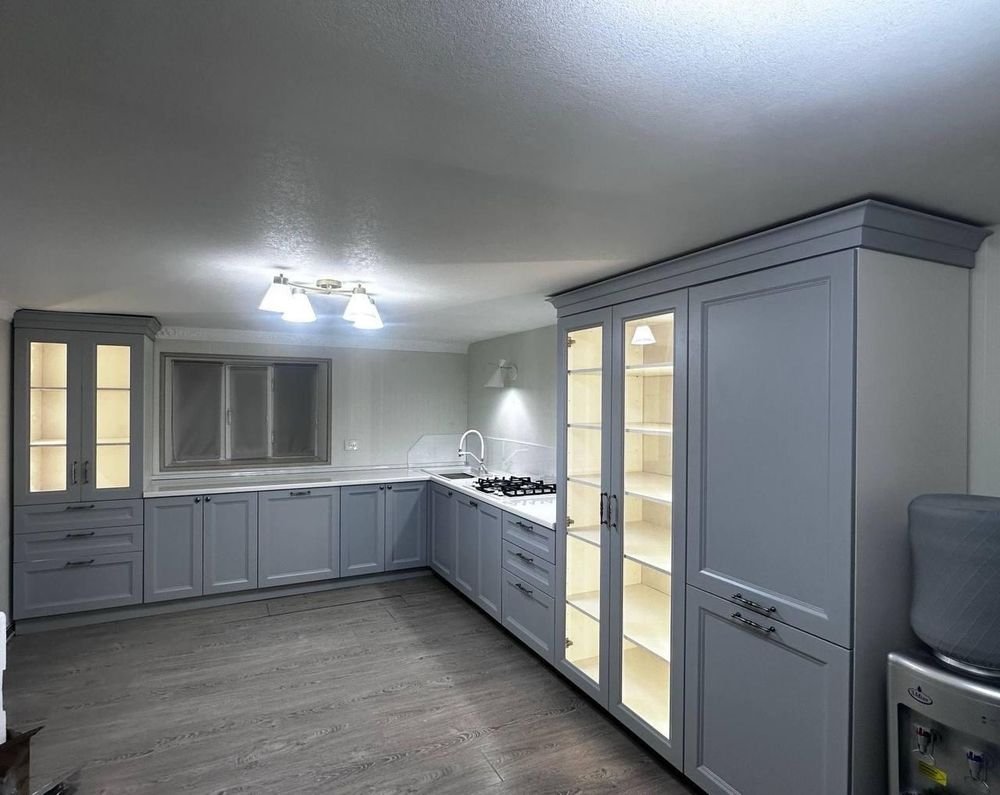Kitchen cabinet refinishing in Redwood City, CA &mdash; dusty blue shaker cabinets with white quartz counters and tall glass-front pantry
