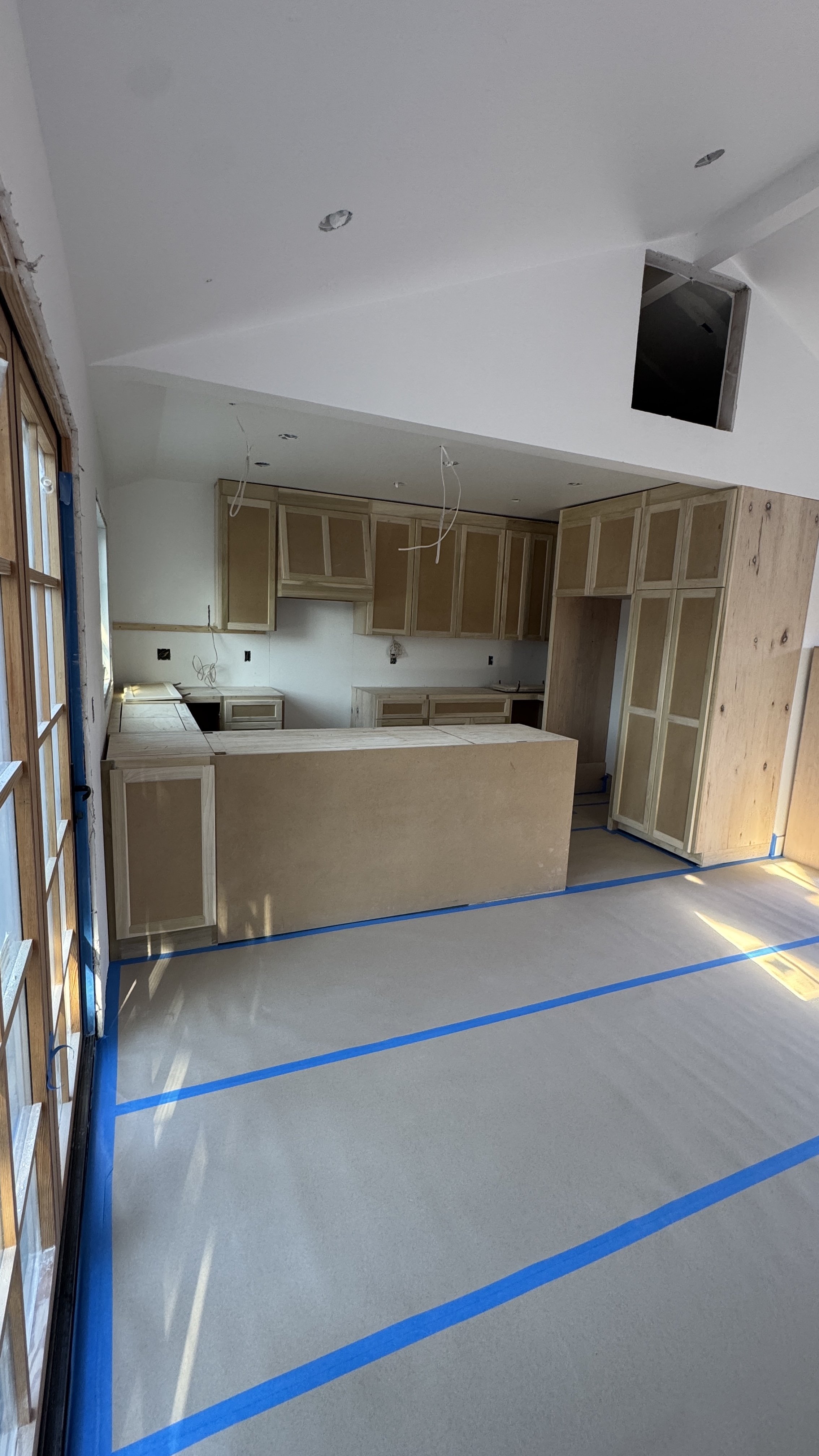 Kitchen cabinet installation &mdash; Base cabinets set, leveled, and floor protected before finish work &mdash; Saratoga, CA