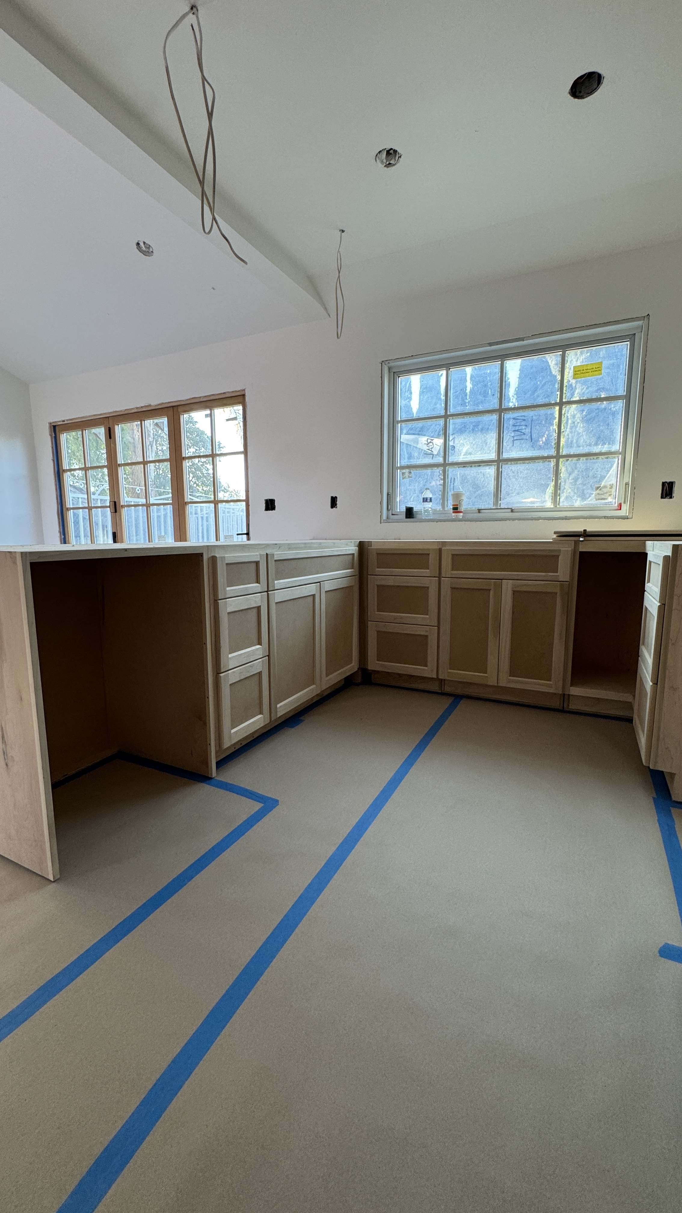 Kitchen cabinet installation &mdash; L-shape layout staged and prepped before spray finishing &mdash; Saratoga, CA