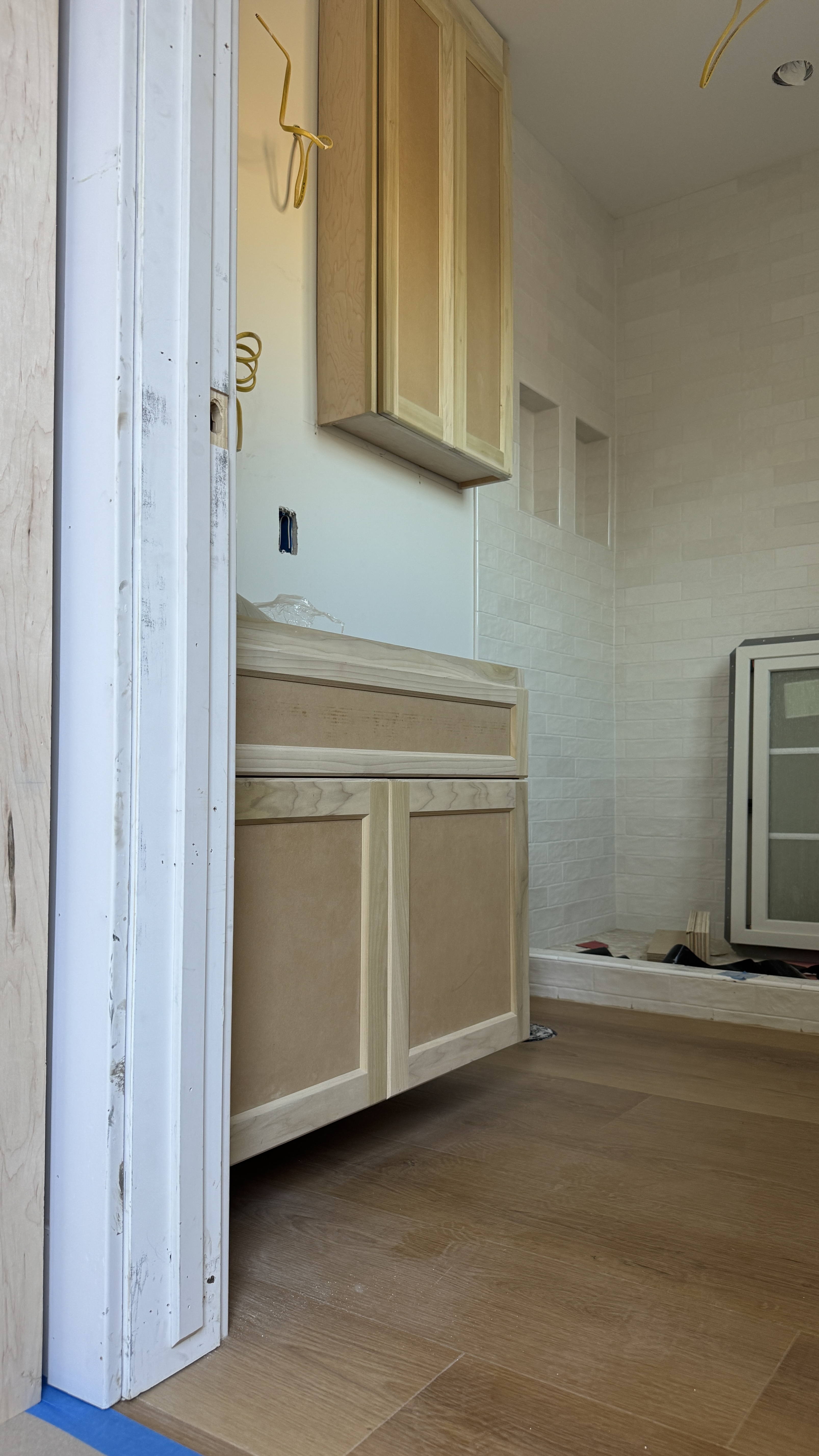 Kitchen cabinet installation &mdash; Cabinet frames secured with wiring and floor protection in place &mdash; Saratoga, CA