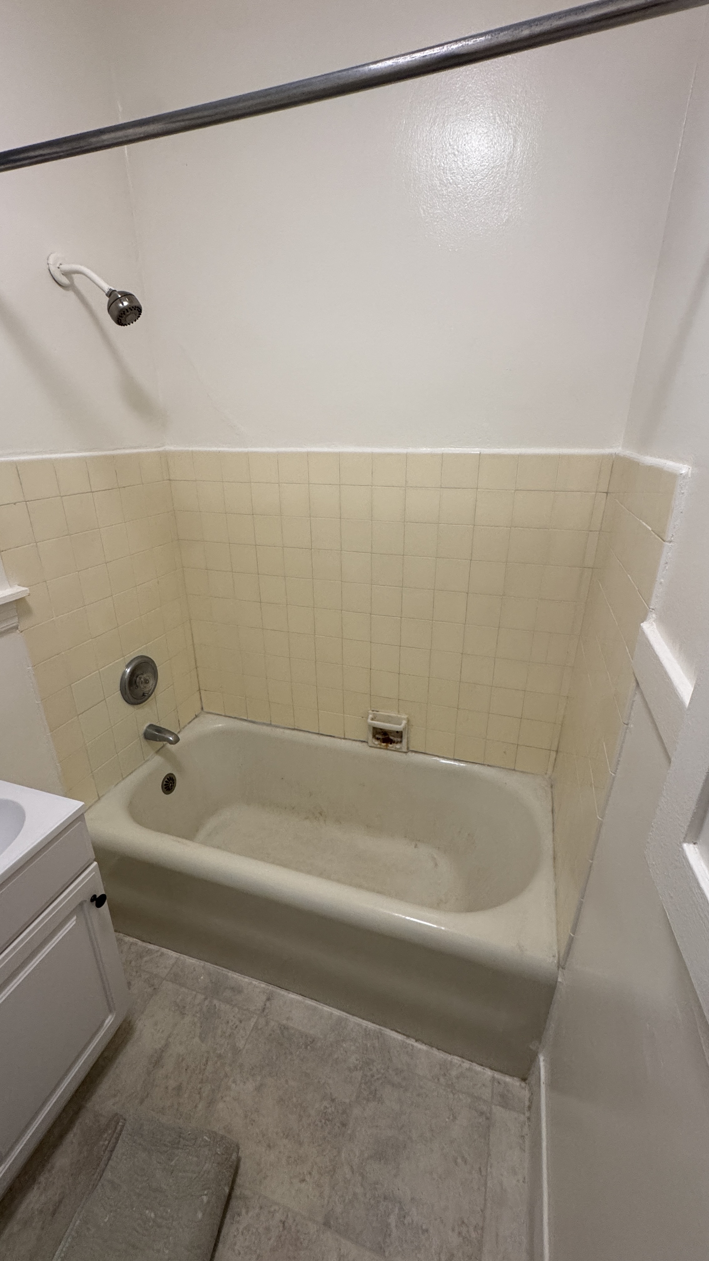Before reglazing in Daly City, CA &mdash; alcove tub and tile surround with yellowed, worn finish