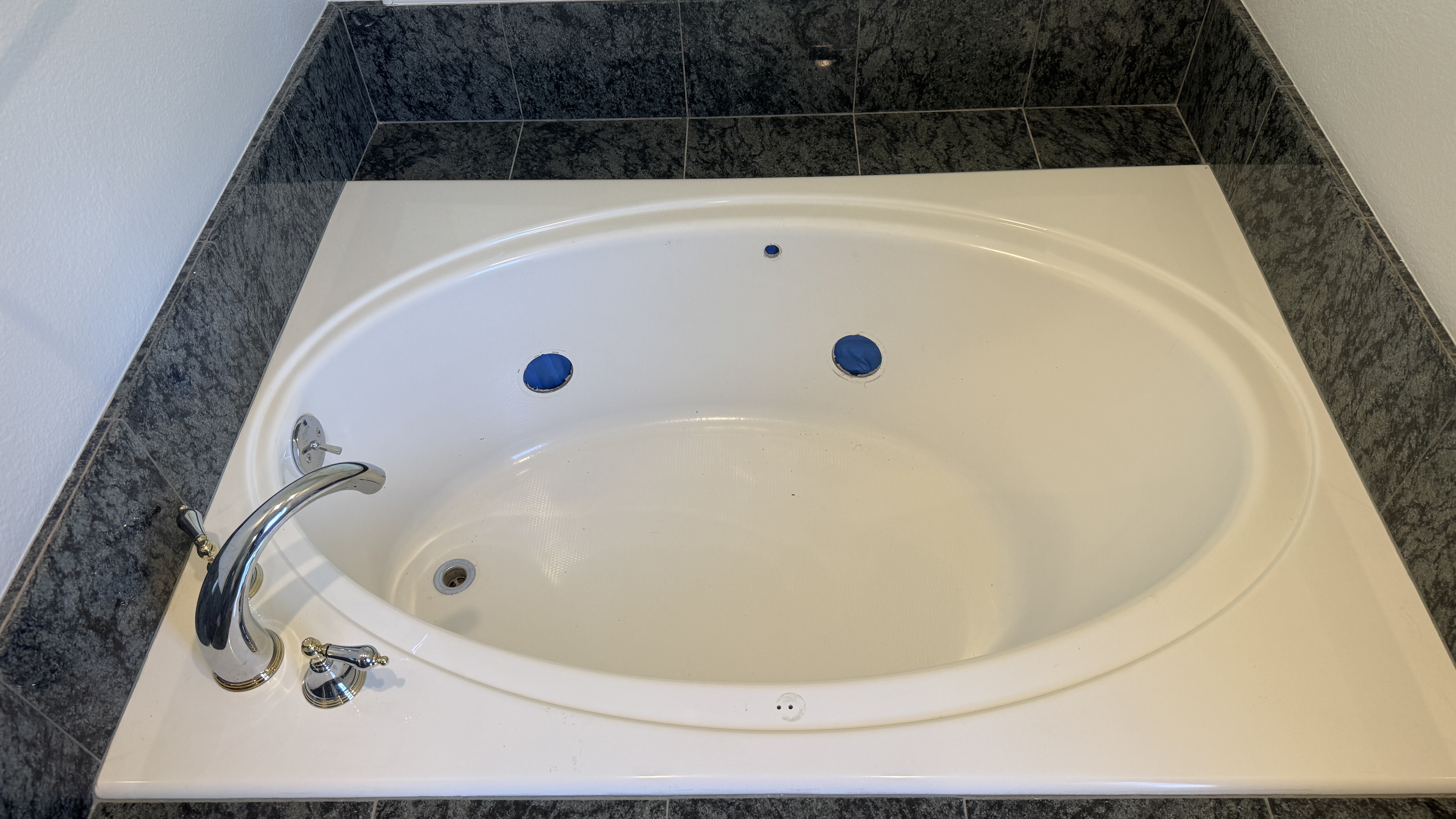 Bathtub reglazing &mdash; Jetted tub masked at ports before etching and spray coating &mdash; Alameda, CA