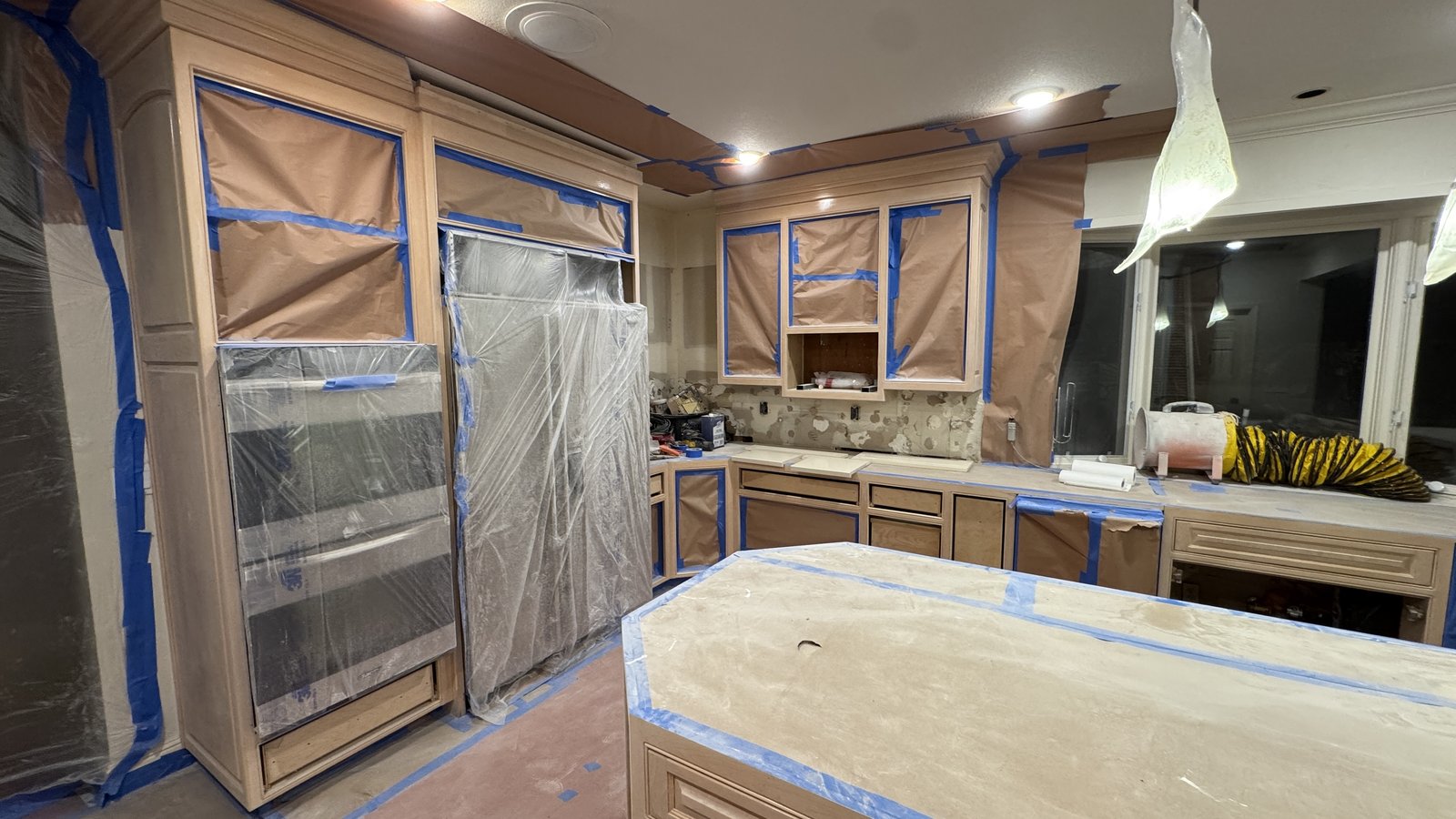 Kitchen cabinet refinishing &mdash; Full kitchen and island masked, primed, and ready for spray application &mdash; Los Gatos, CA