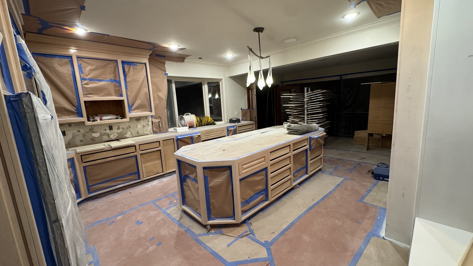 Kitchen cabinet refinishing &mdash; Island and perimeter cabinets masked with drying racks staged on site &mdash; Los Gatos, CA
